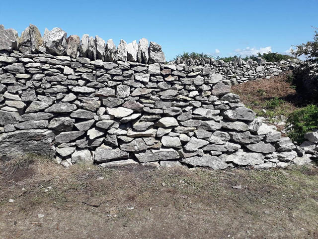 Rhan o'r wal wedi'i hatgyweirio gyda cherrig copa wedi'i chwblhau