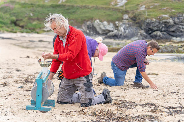 Gwirfoddolwyr yn chwilio am 'nurdles' a phlastig bach ar y traeth