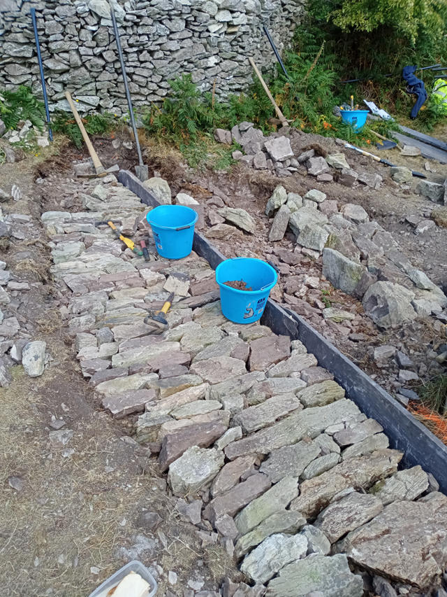 Toriad dŵr bron wedi'i gwblhau yn dangos gwaith carreg