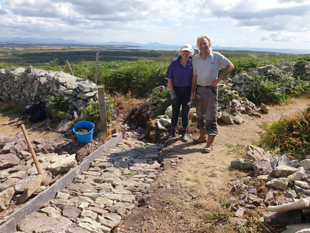 Gwirfoddolwyr gyda'r gwaith carreg a gwblhawyd ganddynt